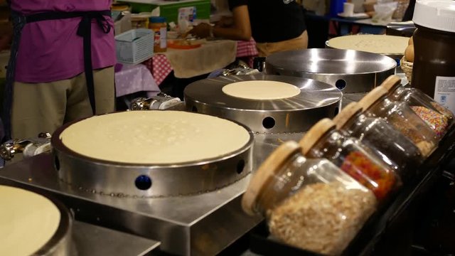 Street vendor cooking delicious pancakes for sale.
