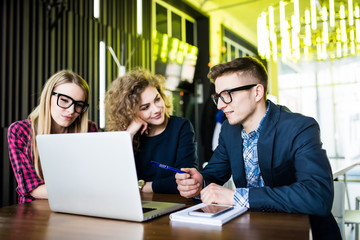 Startup diversity teamwork brainstorming meeting concept. People working planning start up. Group young man women looking over laptop