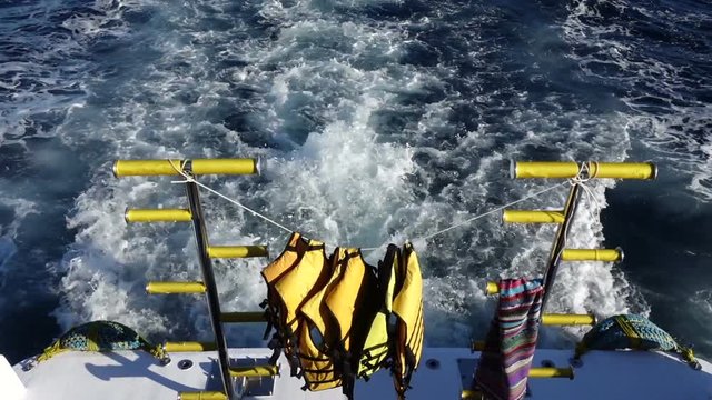 Life vest on ladders on the rear deck of yacht moving in the sea