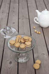 Lady's Kisses - Italian hazelnut sandwich cookies on cake stand with White ceramic teapot