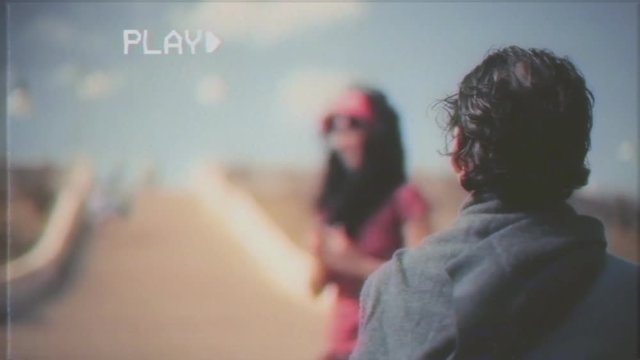 Fake VHS tape: an ugly man kneeling in front of her girlfriend at a romantic place. The woman runs away from the unwanted marriage proposal with the excuse of taking a picture.

