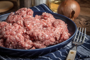 Minced meat on wooden background.