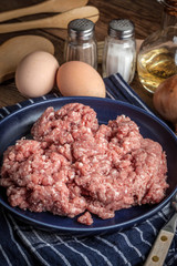 Minced meat on wooden background.