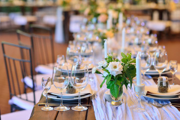 Wedding. Banquet. The chairs and table for guests, decorated with candles, served with cutlery and...