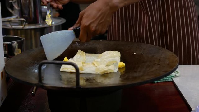 Street vendor cooking delicious pancakes for sale.