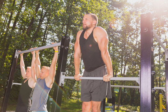 Men doing pull-ups - Powered by Adobe