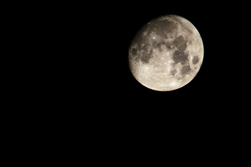 A lightly golden moon with a lot of craters.