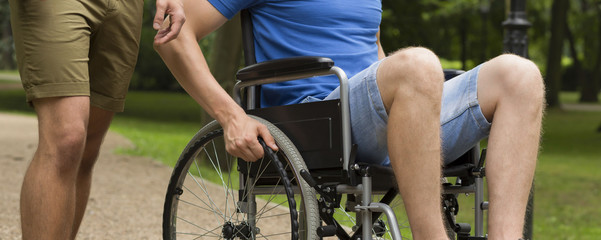 Fototapeta na wymiar Man on wheelchair with friend in park