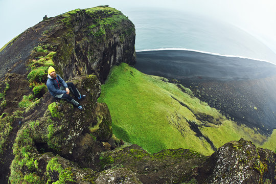 Rreykjavik, Iceland - August 29, 2016: Tourists man setting on Dyrholaey Cliff Iceland