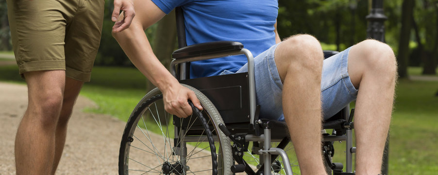 Man on wheelchair with friend in park