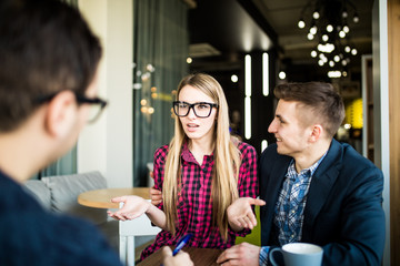 Beautiful couple is talking with manager or realtor, who is making notes. Woman ask something