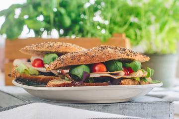 Spring sandwiches with ham, cherry tomatoes, salad and basil