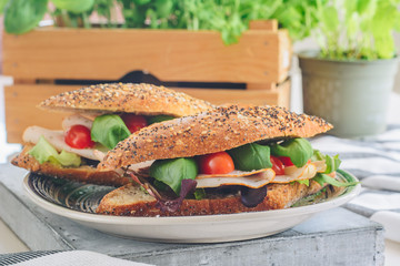 Spring sandwiches with ham, cherry tomatoes, salad and basil