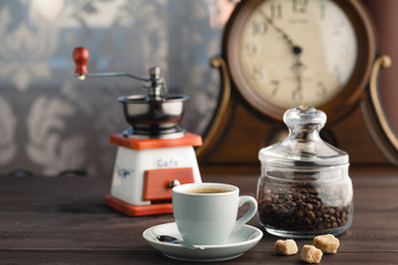 Full jar of coffee beans and mill on table