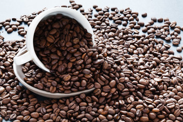 Coffee drinking concept. Rusted beans and cup on table
