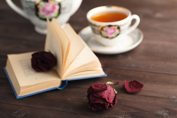 Dried rose laying over an open book
