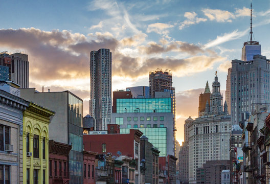 Fototapeta Sunset behind the buildings of Manhattan as seen from Chinatown, New York City NYC