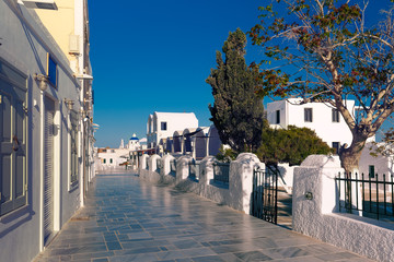 Central tourist street of Oia or Ia with white houses and church with blue domes, island Santorini, Greece