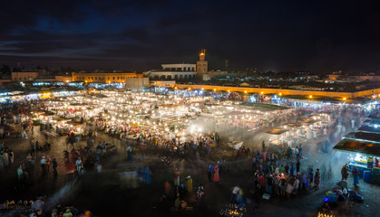 Fototapeta premium Famous square Jemaa El Fna busy with many people and lights during the night, medina of Marrakesh, Morocco
