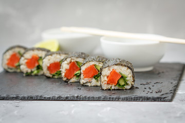 Healthy homemade sushi rolls with brown rice, fish and green vegetable rolls.