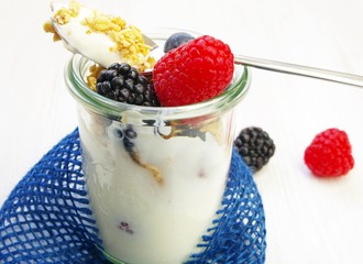 Gesundes Frühstück mit Joghurt, Müsli und Früchten