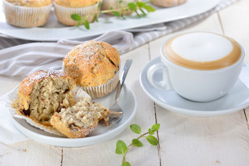 Stracciatella-Bananen-Muffins mit Cappuccino -Freshly baked chocolate banana muffins with a cup of...