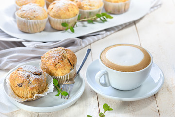 Stracciatella-Bananen-Muffins mit Cappuccino -Freshly baked chocolate banana muffins with a cup of cappuccino