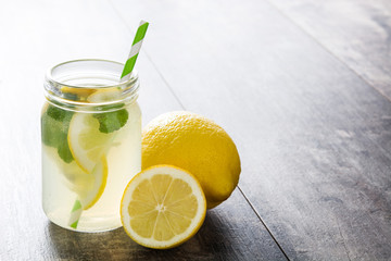 Lemonade drink in a jar glass on wooden background. Copyspace.
