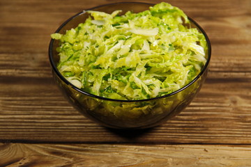 Savoy cabbage salad in glass bowl on wooden table