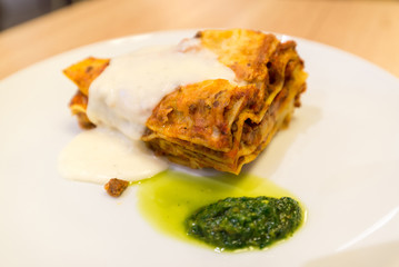 Lasagna with sauce on white plate