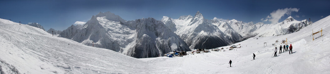 Winter panorama of a mountain landscape, snow-capped peaks and slopes.