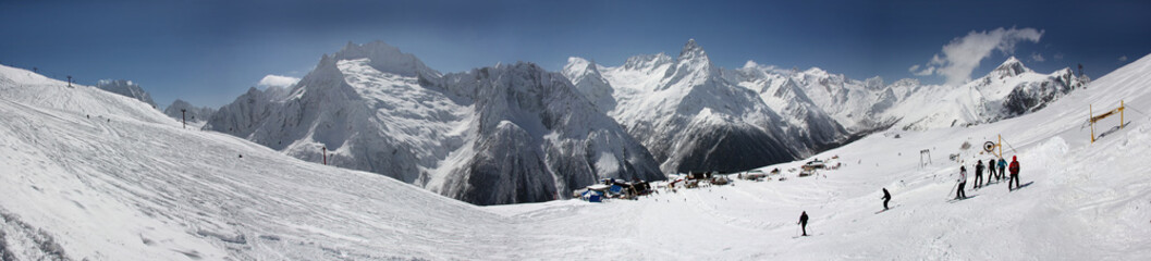 Fototapeta na wymiar Winter panorama of a mountain landscape, snow-capped peaks and slopes.