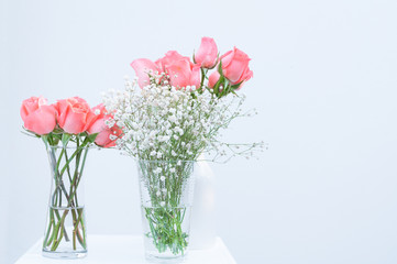 bunch of pink rose eustoma flowers in glass vase on white background
