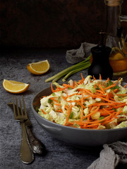 Fresh vegetables salad with cabbage, carrot, parsley on grey clay plate on dark background. Cole Slaw Salad.