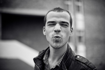 Intense black and white portrait of  man in leather jacket outdoors