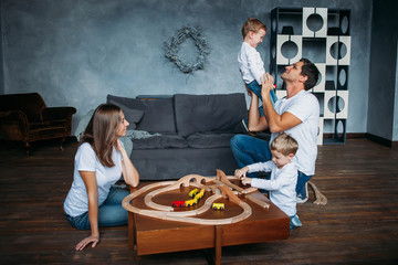 happy family playing with toy railway road at home