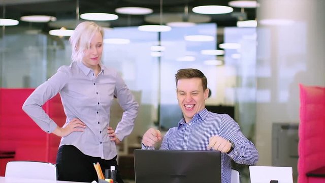 Cute businesswoman dancing with joy, his young colleague woman is upset