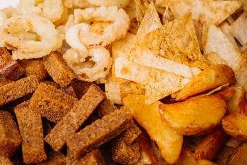 Fast food snacks composition with onion rings,  crackers, baked potatoes, chips, toast.