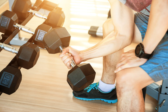 Hand holding dumbbell in the bodybuilding gym