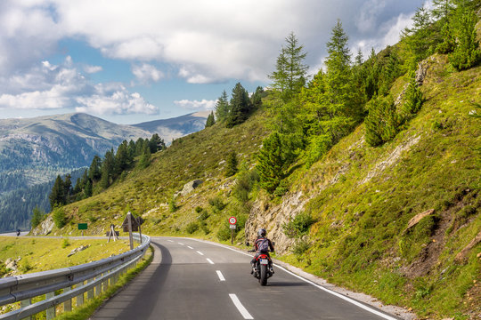 Motorradfahrer auf einer Landstraße im Gebirge