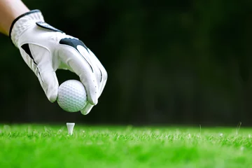 Gordijnen Hand putting golf ball on tee in golf course © bohbeh