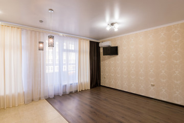 The interior of a small room with a large window without furniture