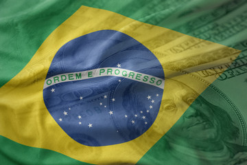 colorful waving national flag of brazil on a american dollar money background. finance concept