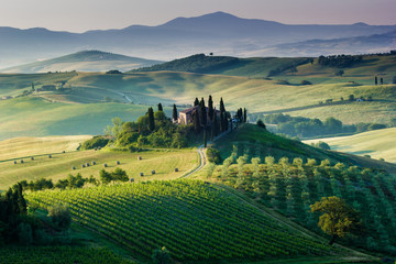 Tuscany, Italy. A beautiful and lonely farmhouse surrounded by green hills of Val d'Orcia