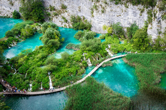 Plitvice Lakes, Croatia, Europe. tourists walking on the pier in the middle of the turquoise lakes