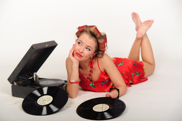 Isolated photograph of a pretty and young pinup girl next to antique record player in a musical...