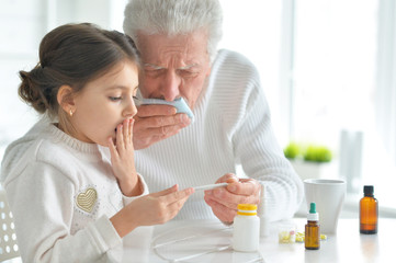 Obraz na płótnie Canvas Granddaughter takes care of a sick grandfather
