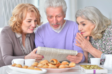 Elderly people having breakfast and reading a newspaper