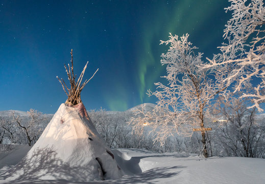 Northern lights over winter landscape with tipi, Lapland