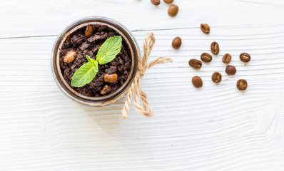 Body scrub of ground coffee on white table background top view